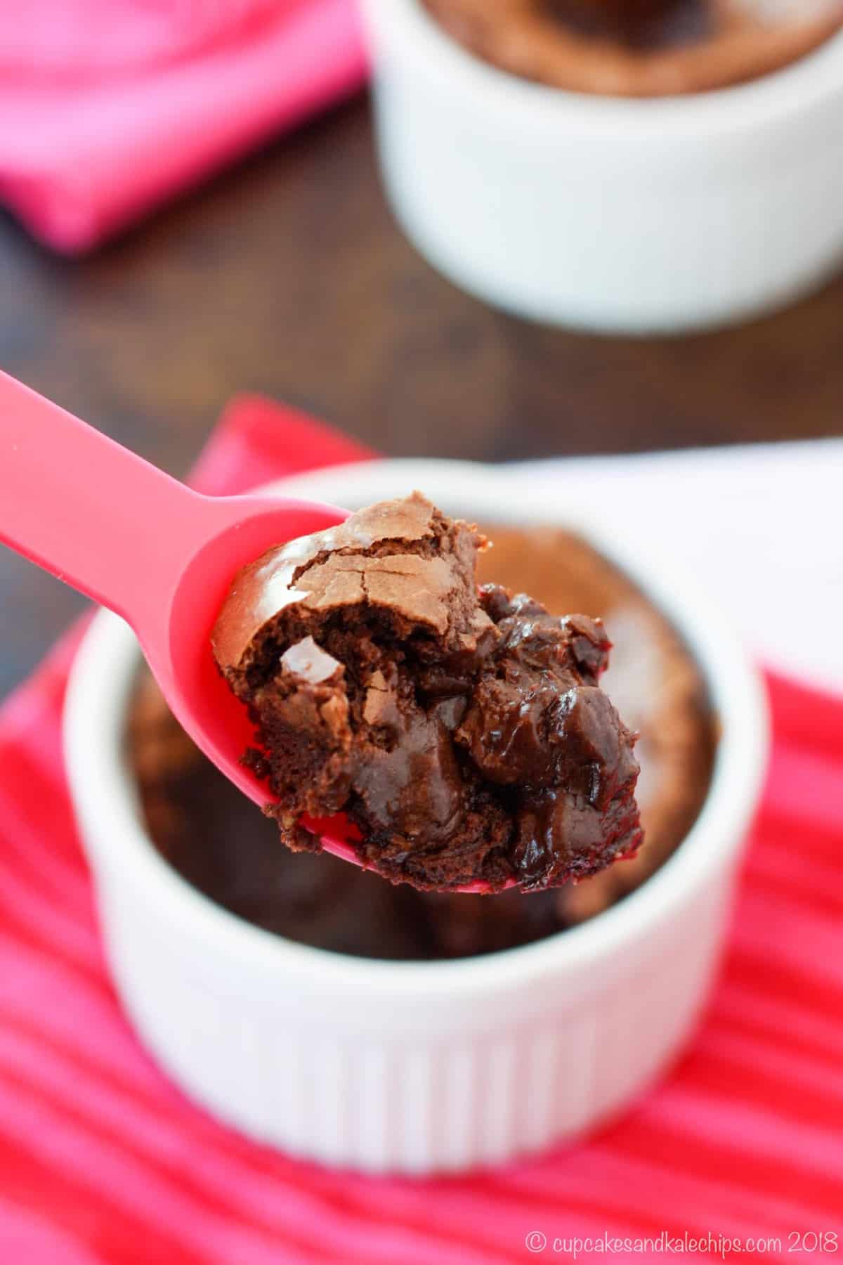 A gluten-free brownie is spooned out of a white ramekin.