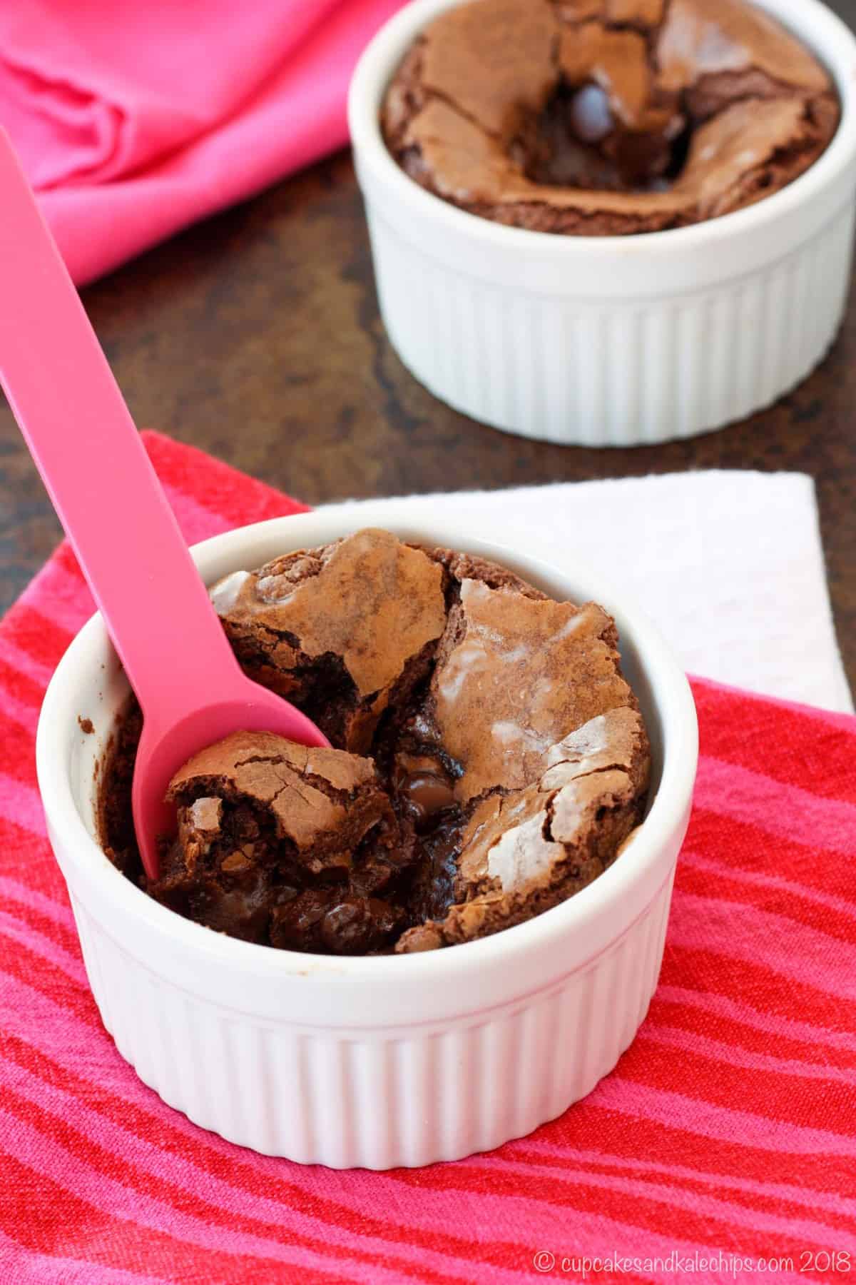 A gluten-free brownie is spooned out of a white ramekin.