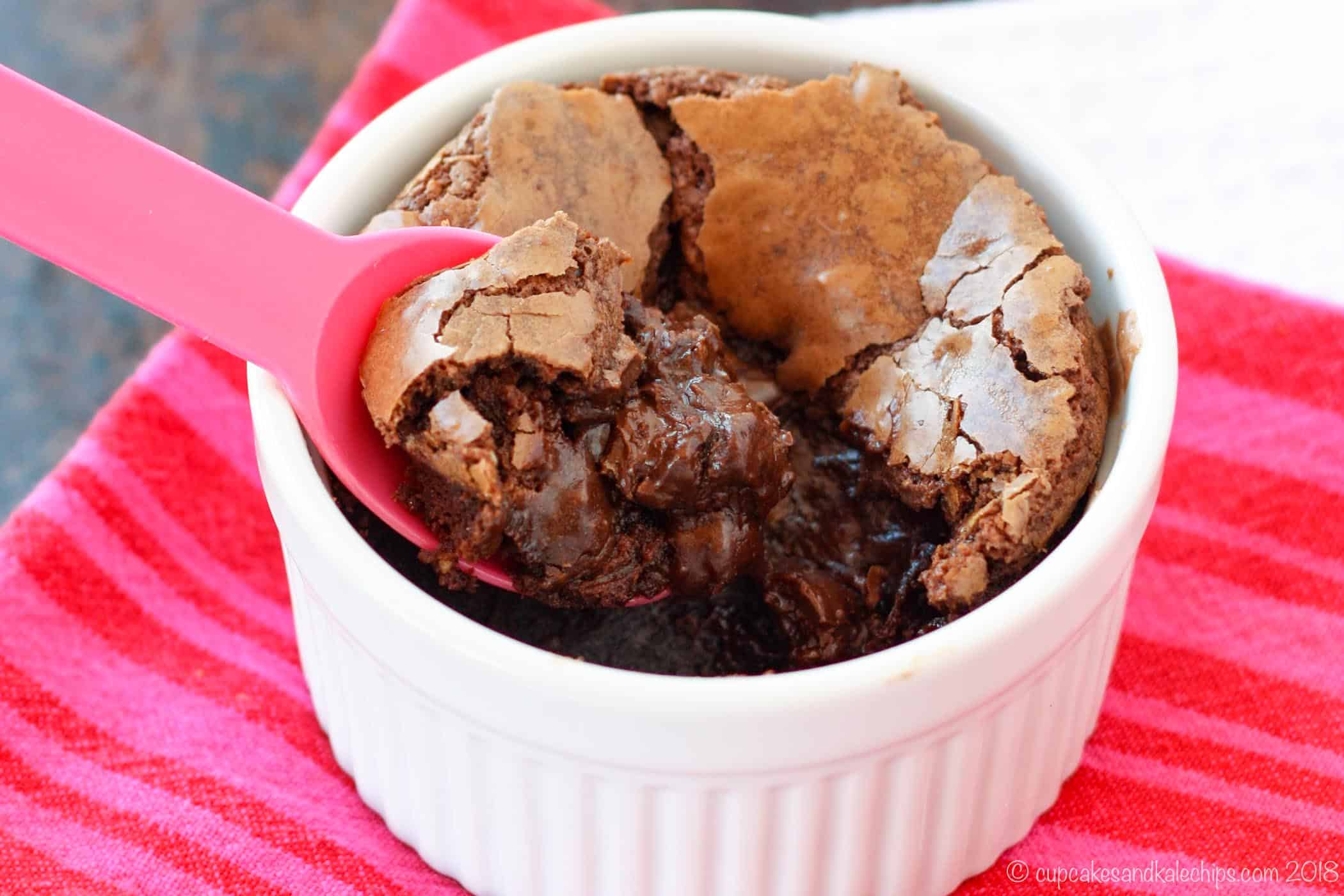 A gluten-free brownie is spooned out of a white ramekin.