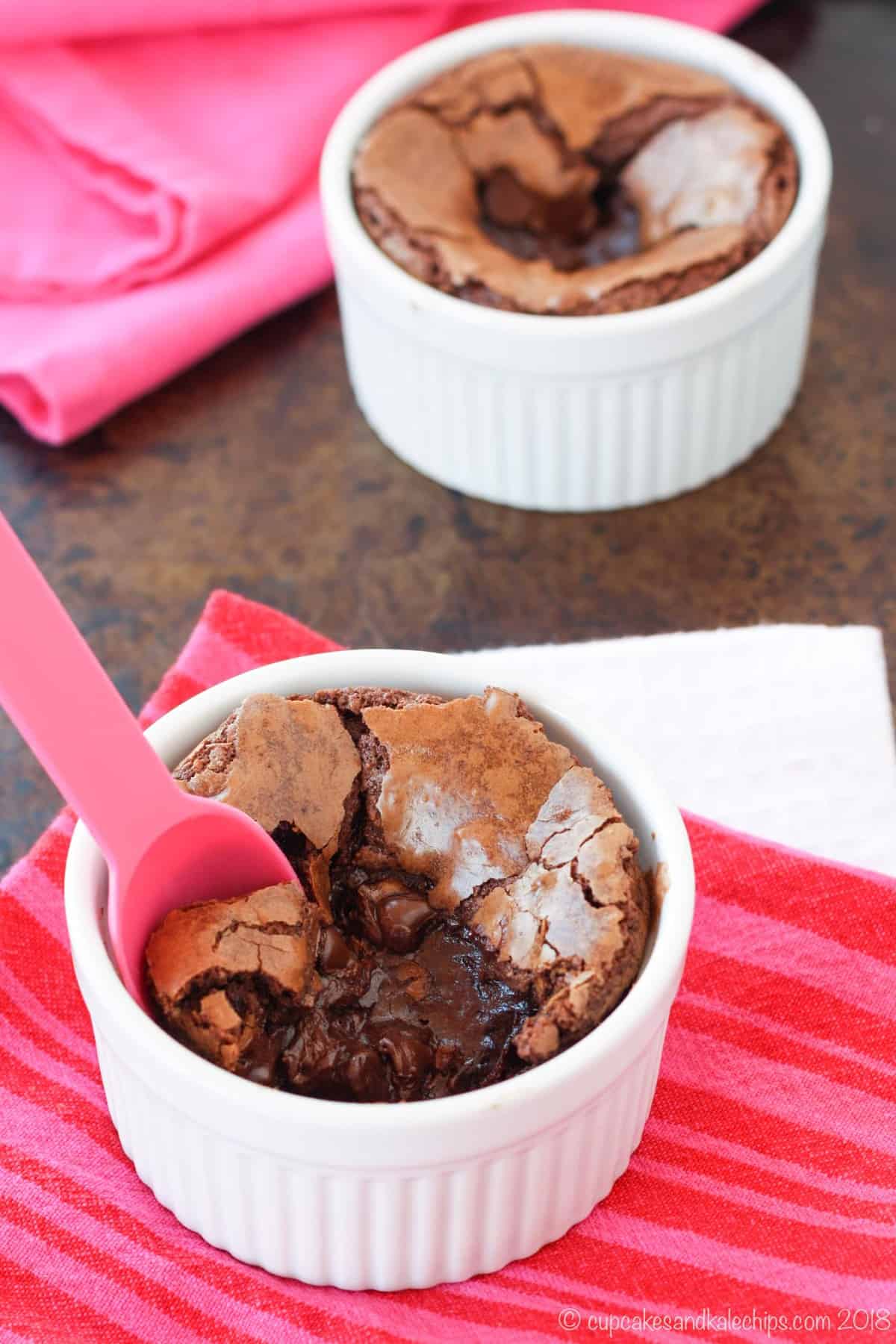 Fudge brownie in a ramekin with a pink spoon.