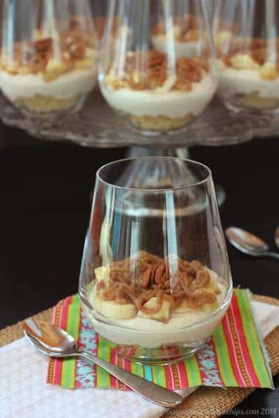 A bananas foster cheesecake parfait in a glass.