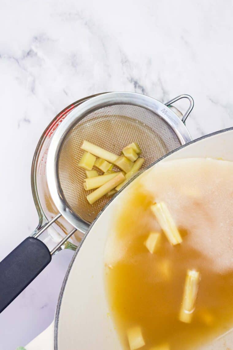 Pouring Asian-style chicken broth through a strainer