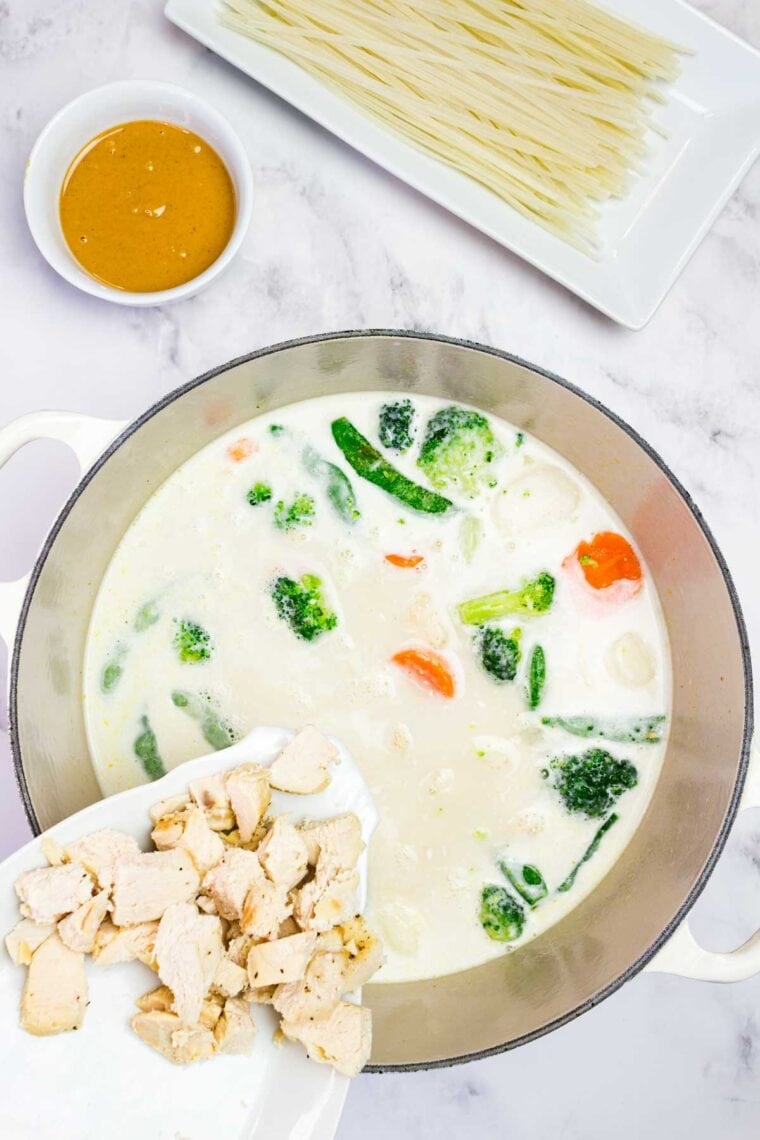 Adding chicken to coconut milk and broth