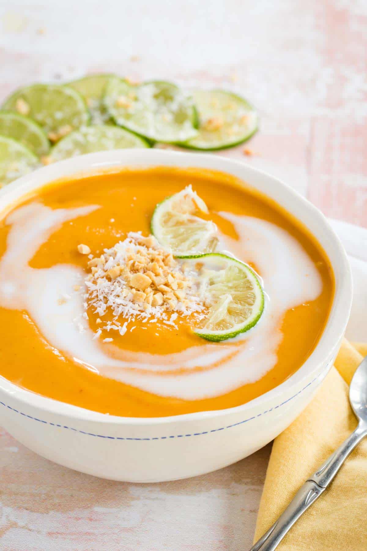 Curried Butternut Squash Soup swirled with coconut milk and garnished with grated coconut and chopped peanuts