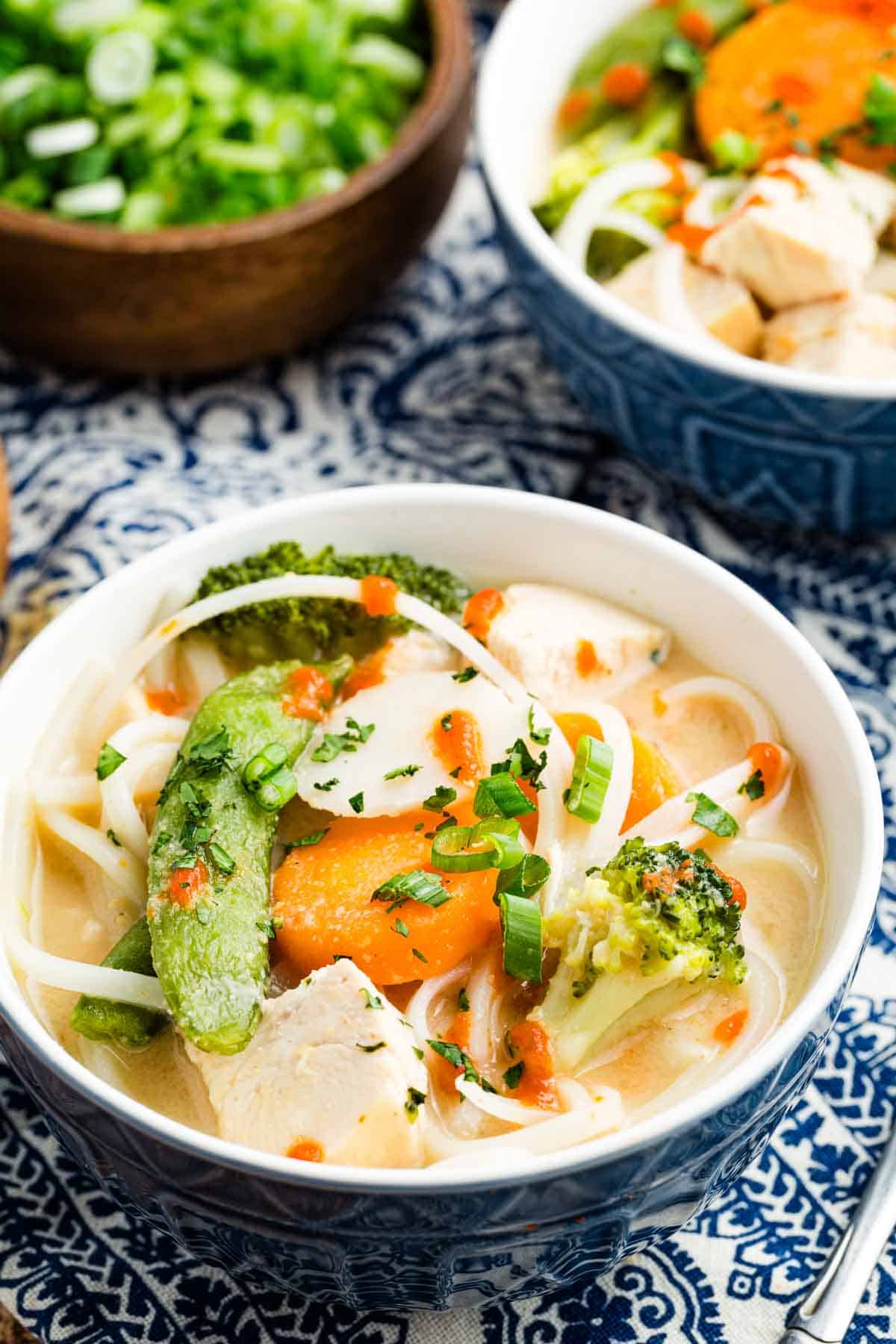Overhead view of a bowl of Thai chicken noodle soup
