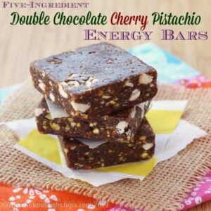 Double chocolate cherry energy bars stacked on parchment paper.