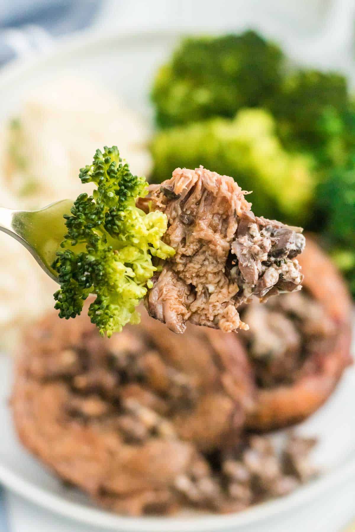 Close up of a forkful of Beef Wellington Braciole with broccoli.