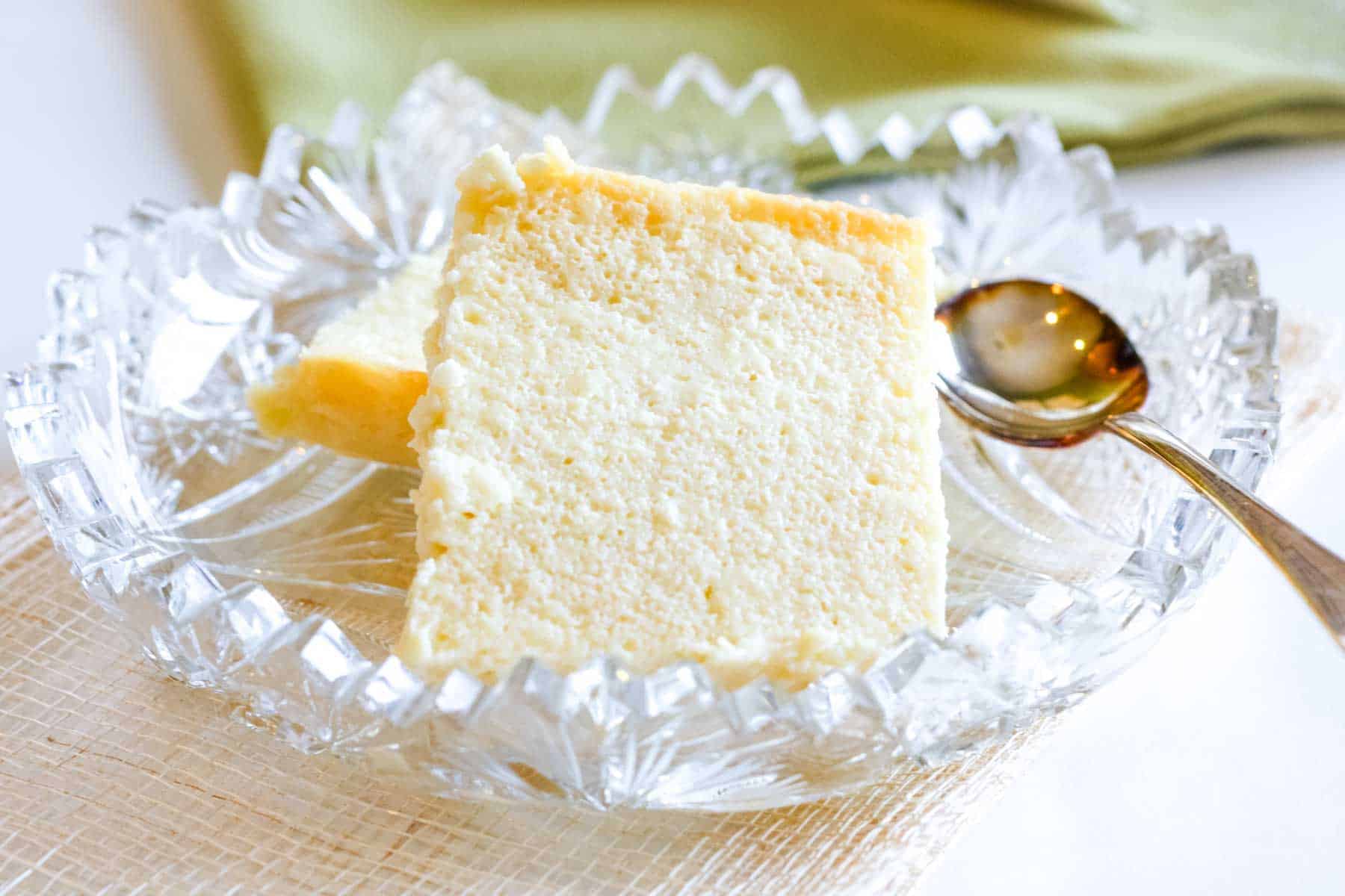 Two squares of Ukrainian sweet cheese in a crystal dish with a spoon.