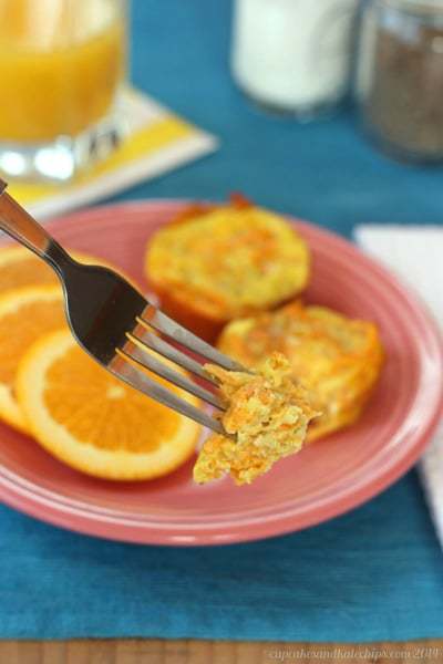 A forkful of apple sweet potato egg muffin with the egg muffin cups in the background.