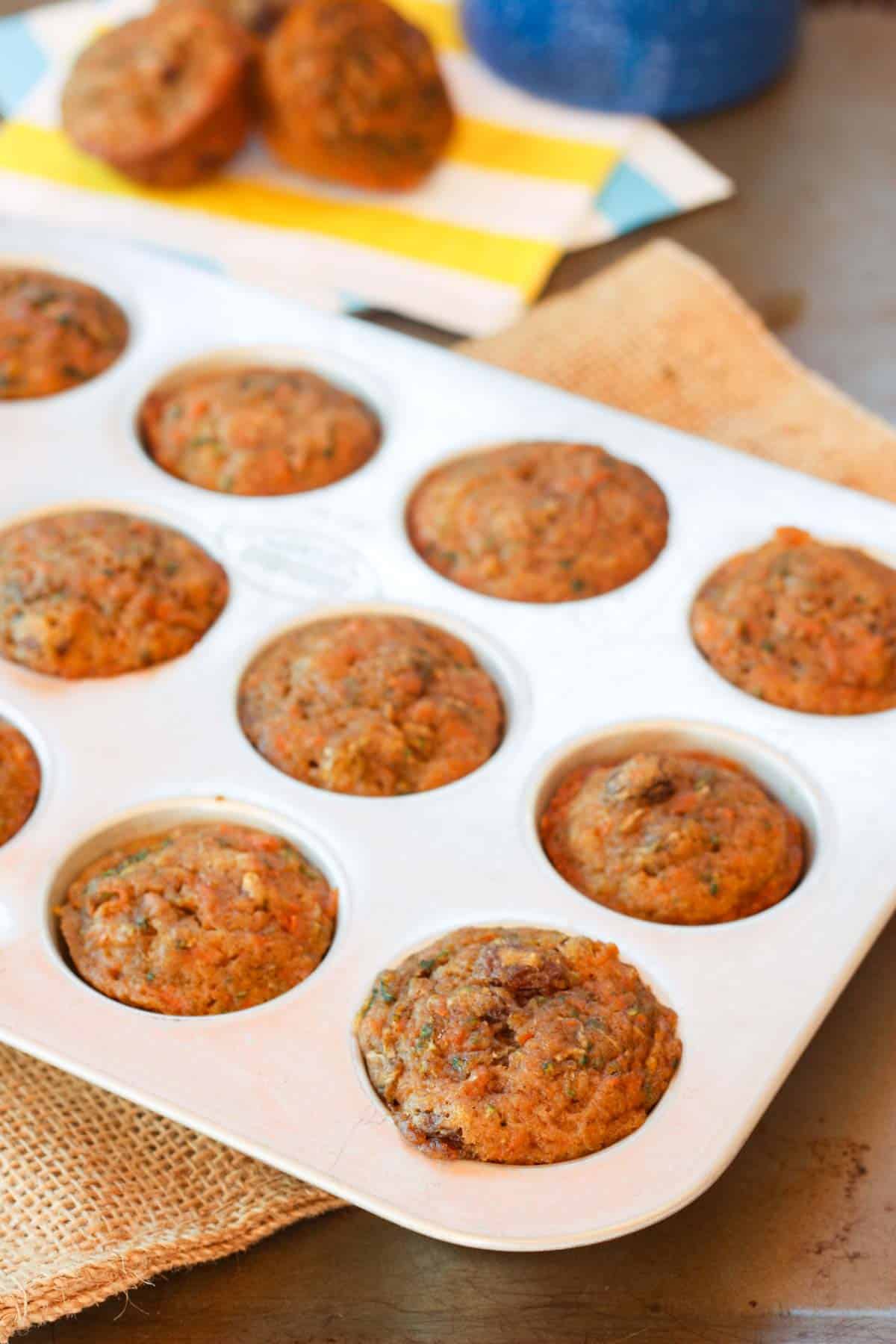 A mini muffin tin filled with zucchini carrot muffins