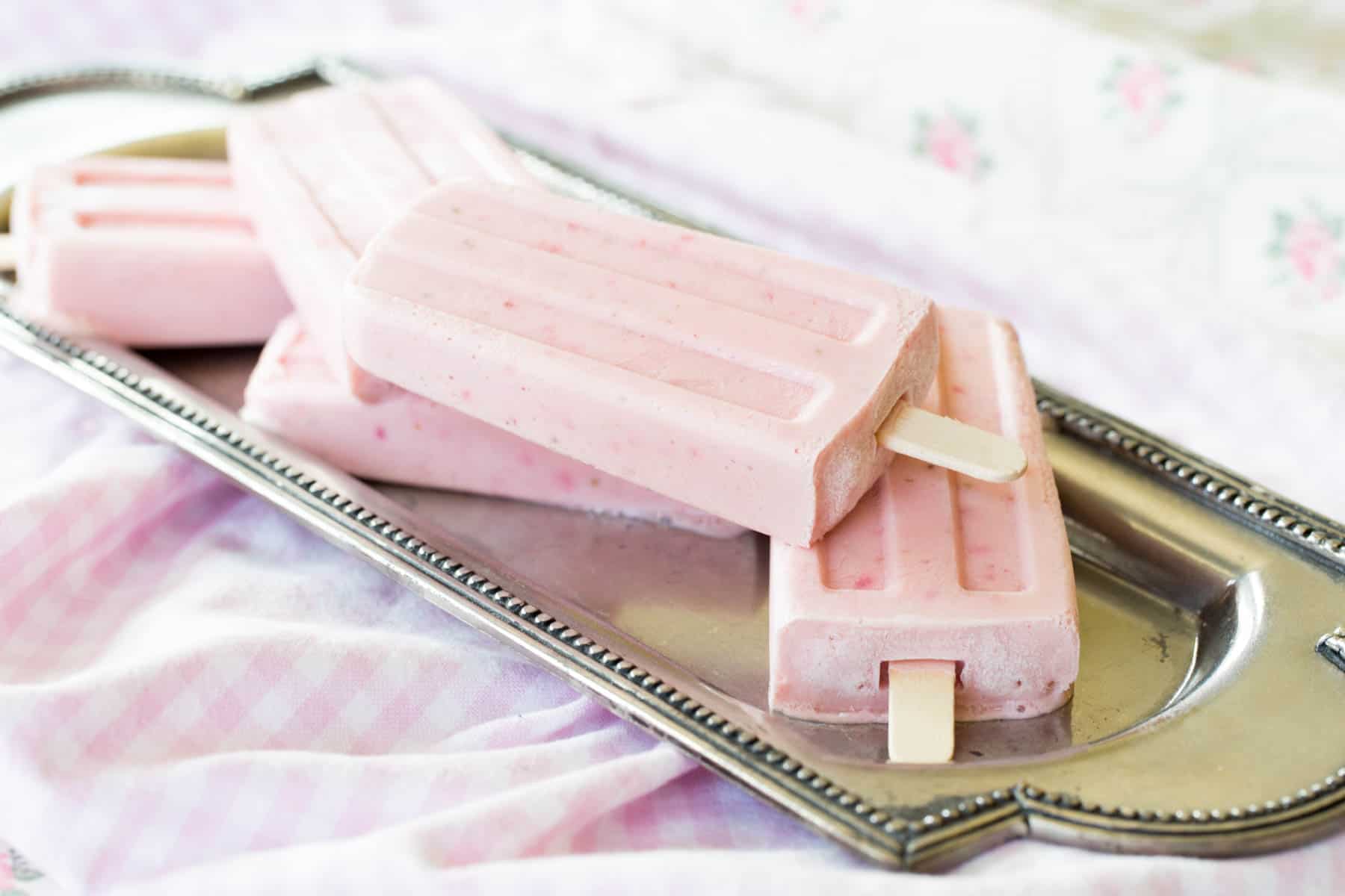 Strawberry Cheesecake Frozen Yogurt Popsicles on a silver platter