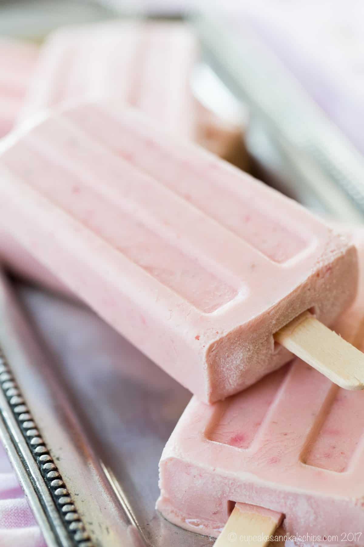 Strawberry Cheesecake Frozen Yogurt Popsicles on a pewter tray