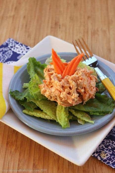 Buffalo Chicken Salad with blue cheese on top of fresh greens.