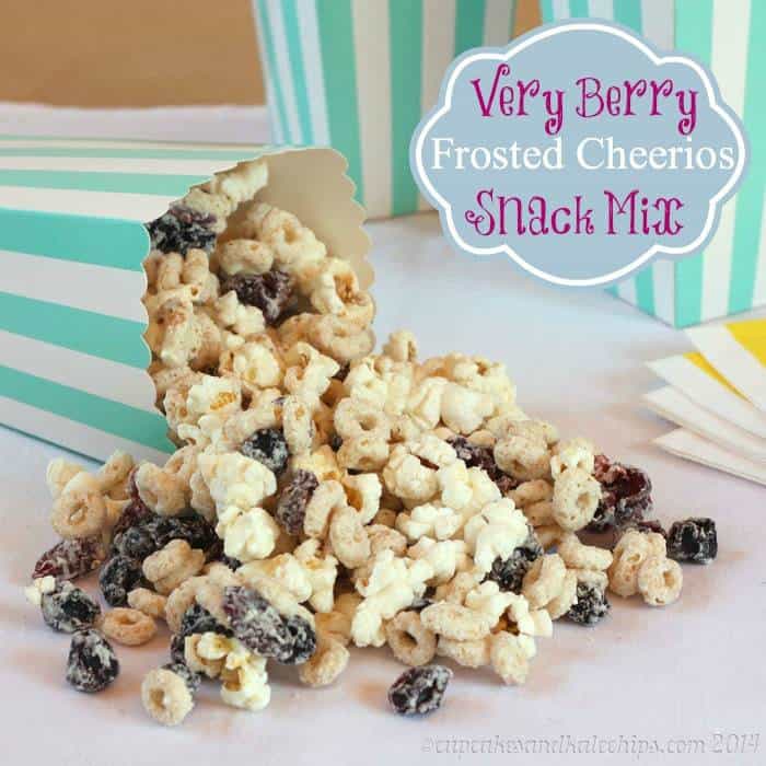 Very Berry Cheerios Popcorn Snack Mix spills out from a blue and white striped popcorn bag.