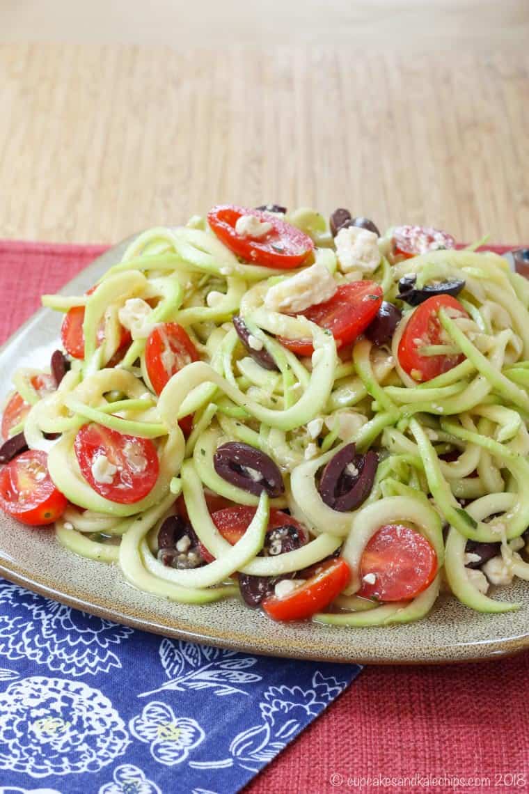 plate of zucchini noodles with tomatoes, feta cheese, and olives