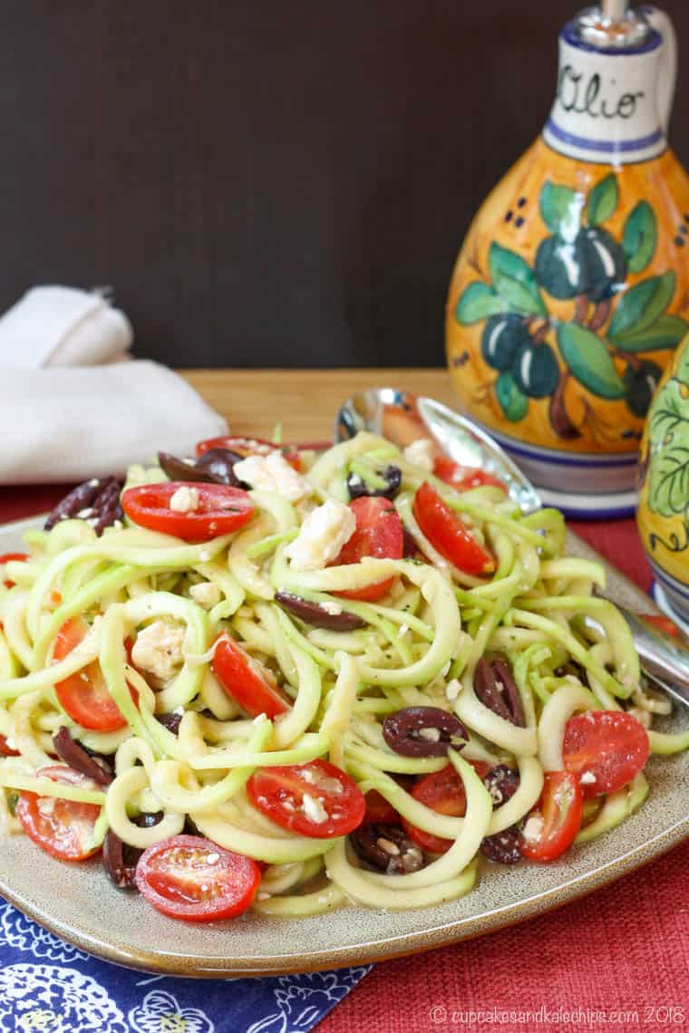 Greek Zoodle Salad on a plate with a black background