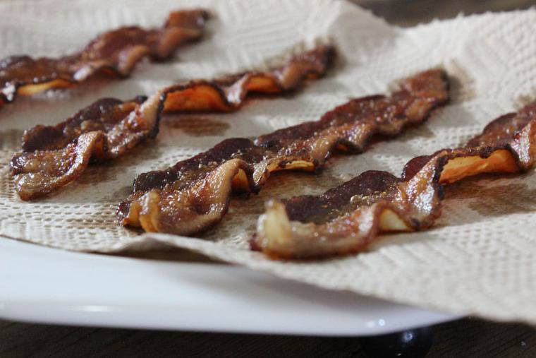 Bacon strips laid out on a paper towel.