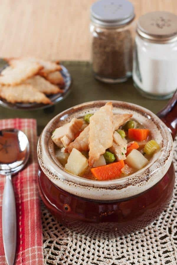 Easy Turkey Soup topped with pie crust crackers in a soup crock