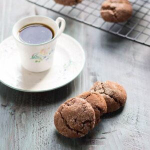 Espresso snickerdoodles next to a cup of coffee.