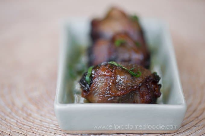 Bacon wrapped dates on a rectangular serving plate