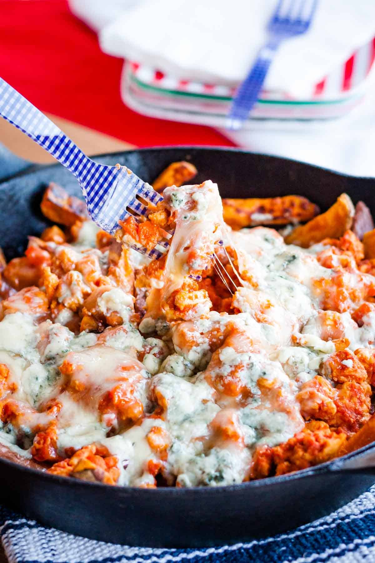 Skillet filled with buffalo chicken fries.