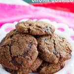 A small white plate of cookies with text overlay that says "Flourless Dark Chocolate Chunk Cookies".
