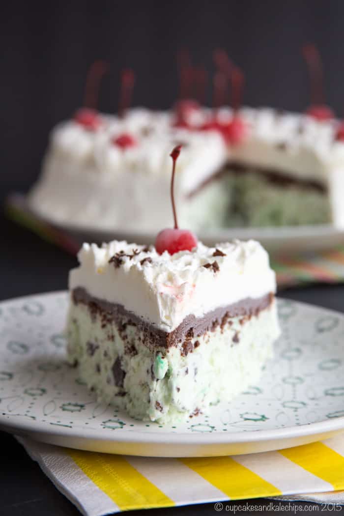 slice of mint chocolate chip ice cream cake topped with a maraschino cherry on a plate