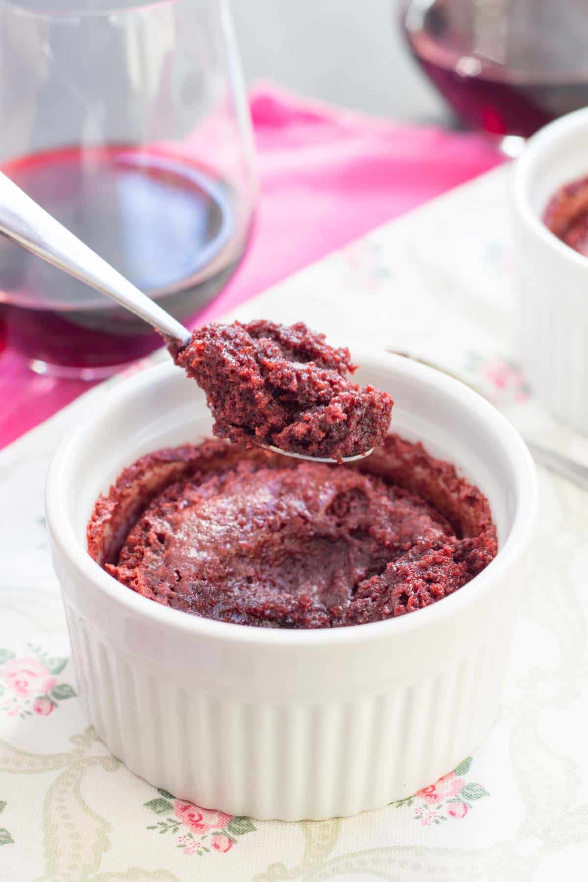 A Red Velvet Brownie in a ramekin with a bite being picked up on a small spoon.