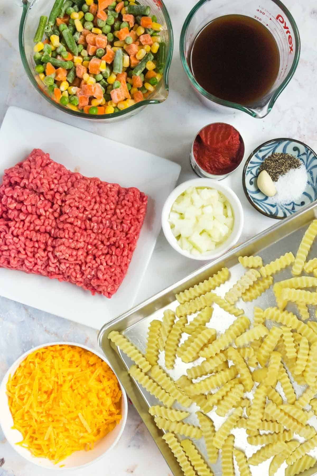 Ingredients to make Shepherd's Pie Loaded Fries on a marble countertop.