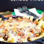 French fries covered with a ground beef and veggie mixture and melted cheese in a cast iron skillet with text overlay that says "Shepherd's Pie Loaded Fries".