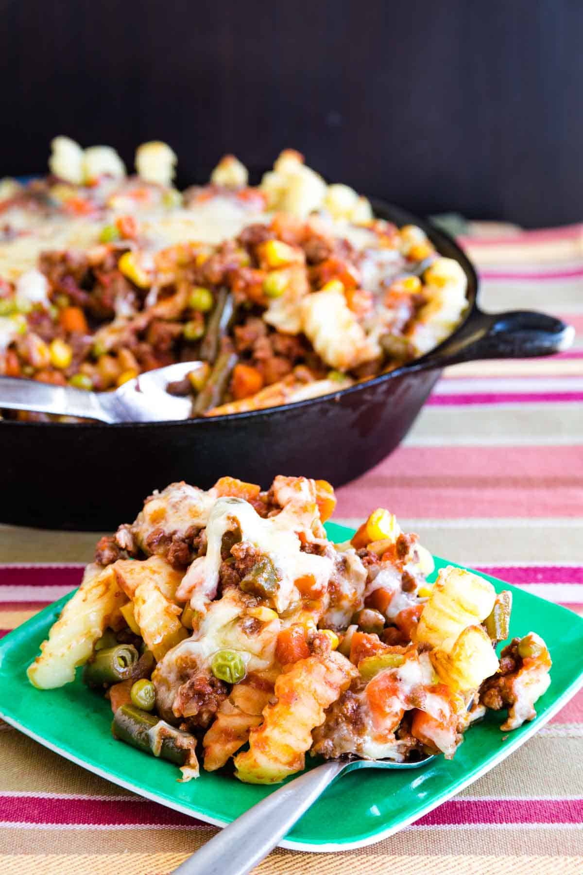 A green plate with a serving of Shepherd's Pie Loaded Fries