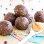 A pile of energy balls on cloth napkins with text overlay that says "Banana Chocolate Chip Peanut Butter Energy Balls".