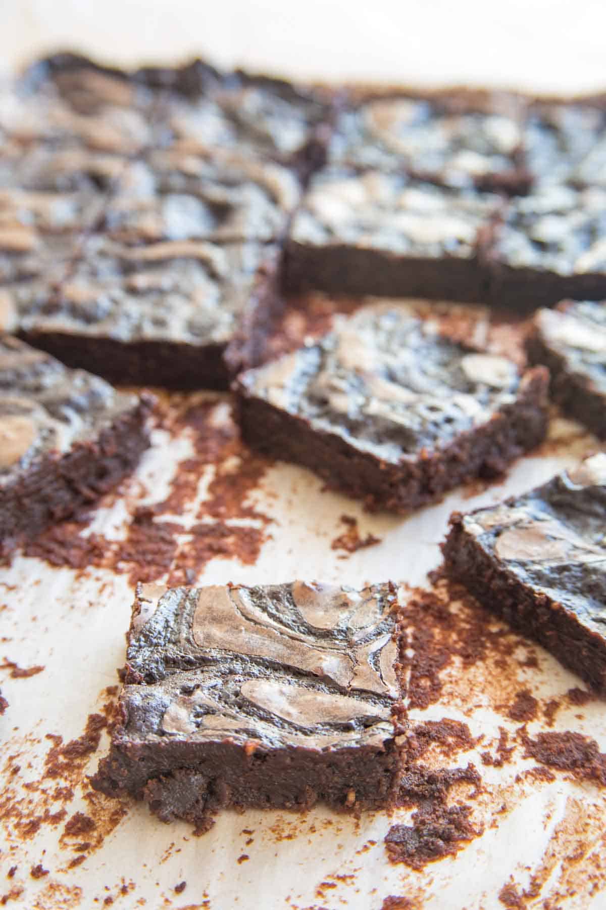 Cut up flourless brownies with Irish Cream fudge swirl on parchment paper.