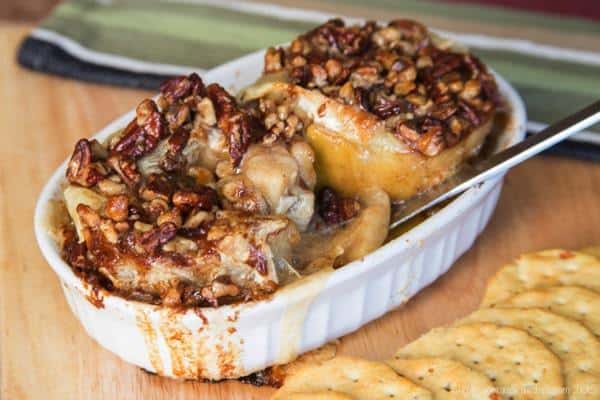 Honey Nut Baked Brie Bloomin' Apples served in a baking dish next to crackers