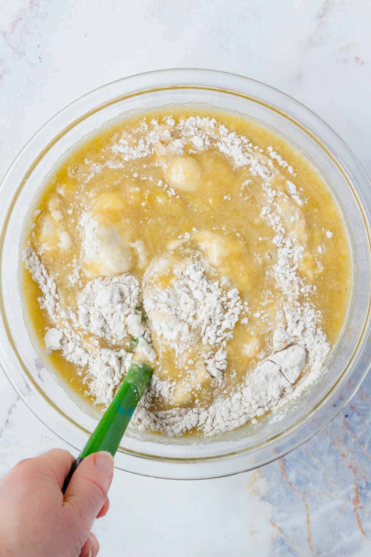 The wet and dry ingredients are stirred together in a mixing bowl.