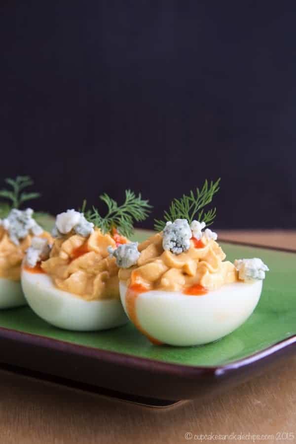 Buffalo Blue Cheese Deviled Eggs topped with more blue cheese and hot sauce