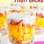 Layered fruit salad of tropical fruits in a glass with coconut chia seed cream on top.