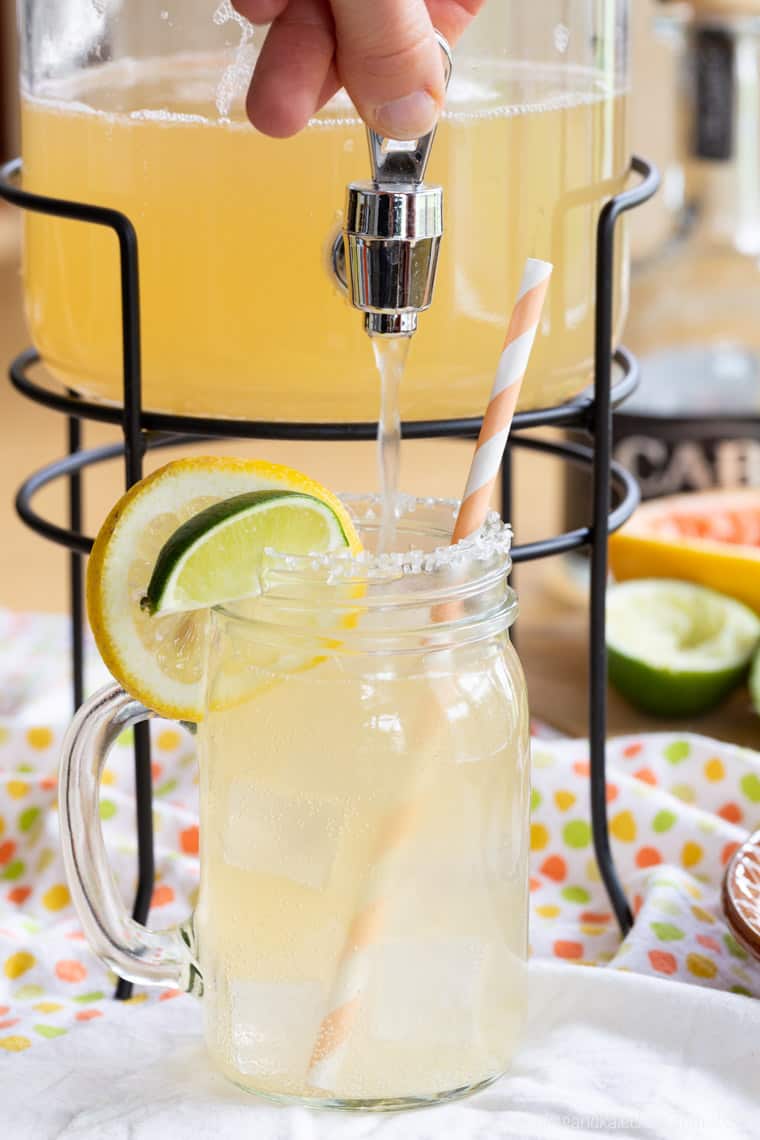 Light Grapefruit Margarita in a pitcher filling a glass with this cocktail recipe