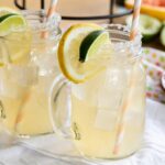 A pair of Skinny Grapefruit Margaritas with lemon and lime wedges.