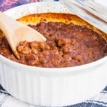 wooden spoon in a casserole dish baked beans