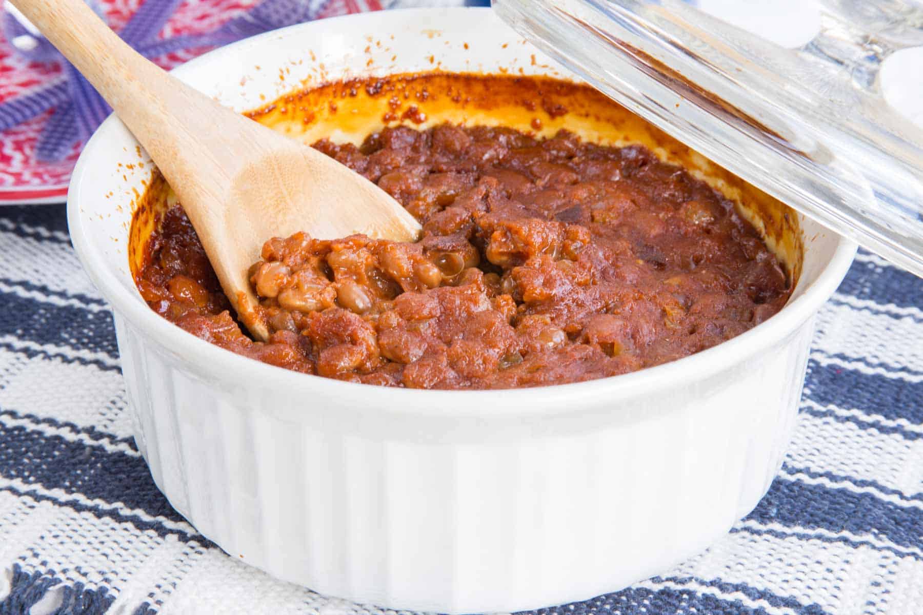 wooden spoon in a casserole dish baked beans