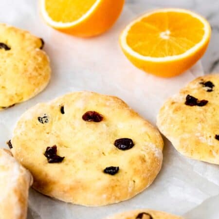 Assorted cranberry orange pita bread on a marble countertop next to two halves of an orange.