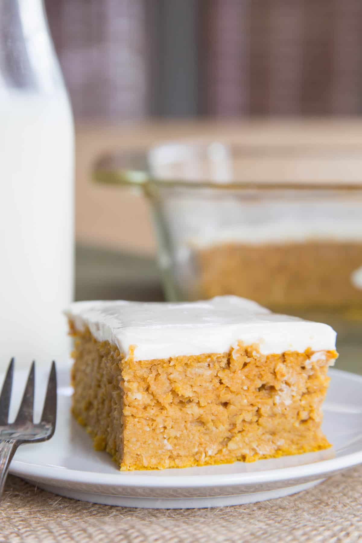 A square slice of baked pumpkin snack cake on a plate