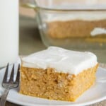 Pumpkin Snack Cake served with Greek Yogurt Cream Cheese Frosting on a white plate with a small dessert fork