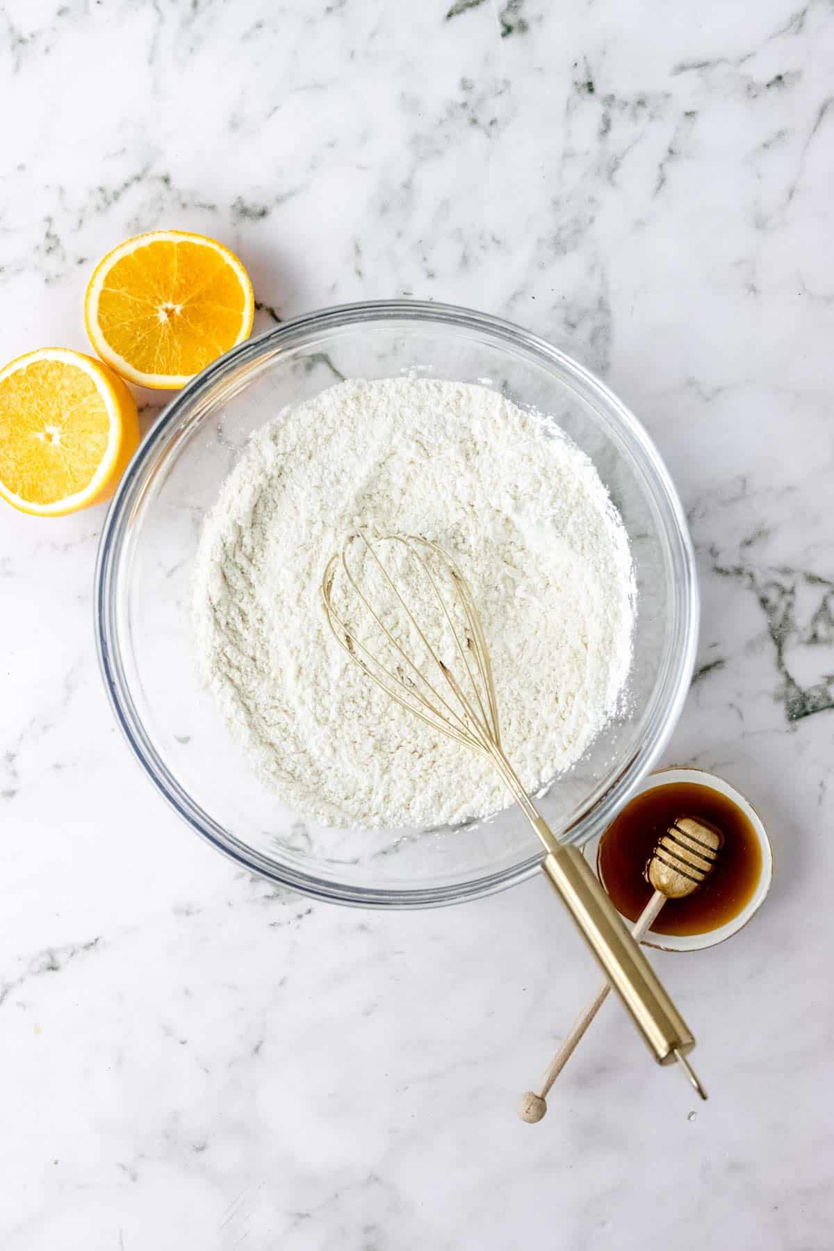 The dry ingredients for homemade pita bread dough combined in a glass bowl with a whisk.