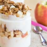 A closeup of the side of an apple parfait to show the yogurt, apple, and granola layers.