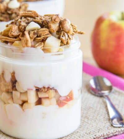 A closeup of the side of an apple parfait to show the yogurt, apple, and granola layers.