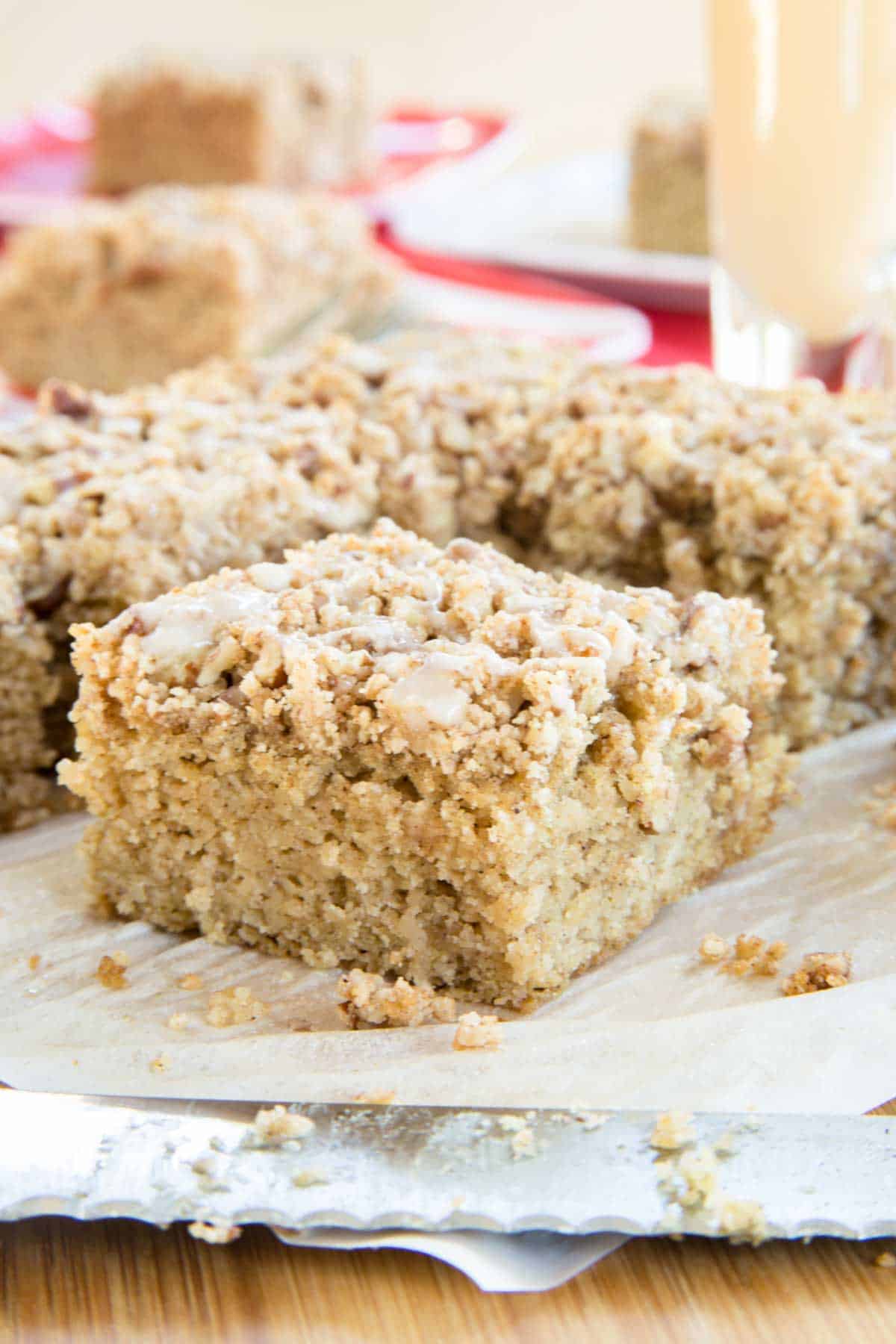 Squares of coffee cake on a cutting board with a knife laying in front.