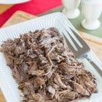 Shredded beef on a white rectangular platter.