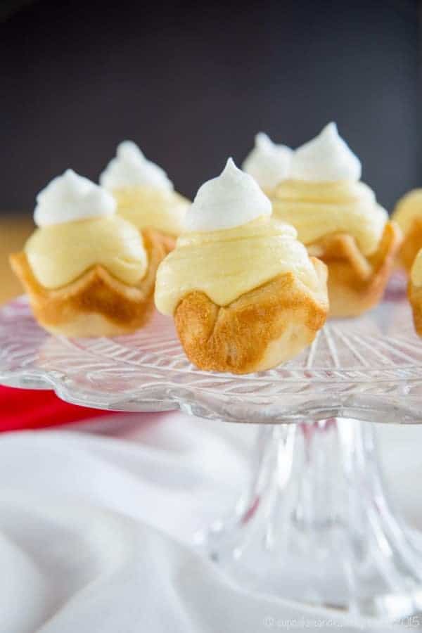 Mini Eggnog Cream Pies served on a glass cake stand for an easy Christmas dessert